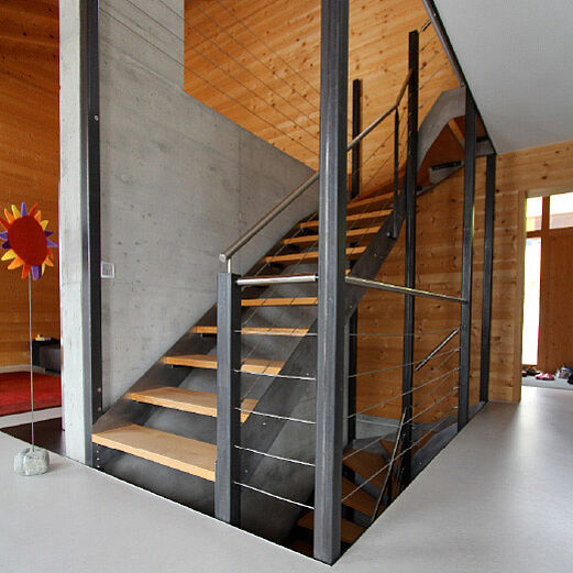 Einfamilienhaus Sent | Innentreppe aus Stahl roh mit Holztritten